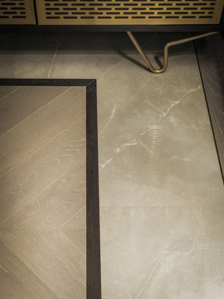 timber flooring in an interesting pattern with marble inlays or borders and brass trims