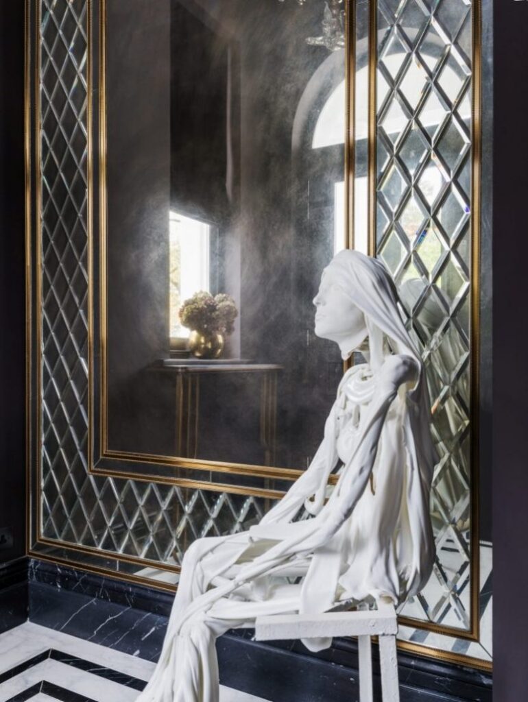 statue next to mirror in hallway