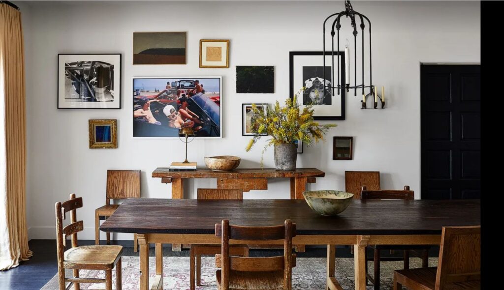 A Waldo’s Designs iron chandelier hangs above a walnut-and-oak dining table