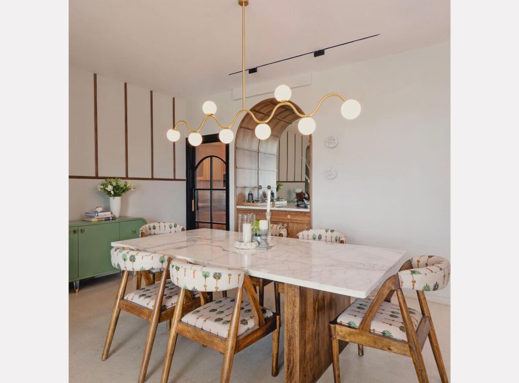 wave length gold chandelier above kitchen table by arjun rathi design 